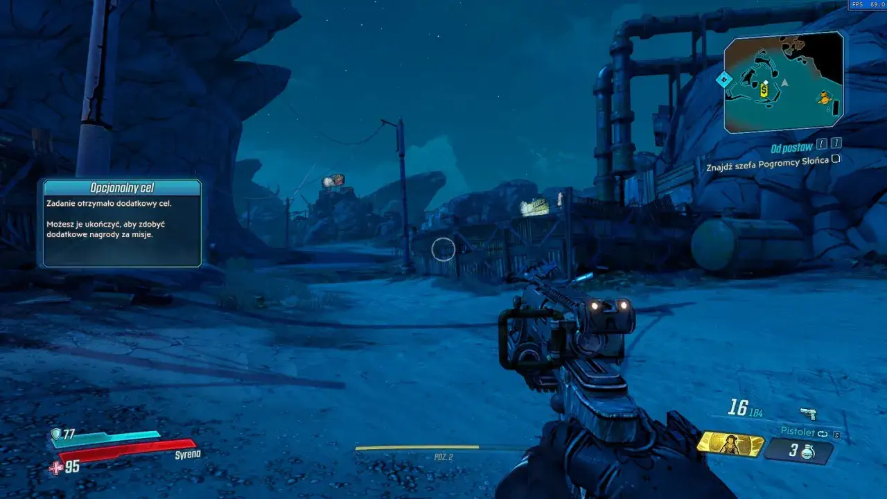 Gra Borderlands 3 spolszczenie. Widok z perspektywy pierwszej osoby na pustynny krajobraz z budynkami i bronią w ręku.