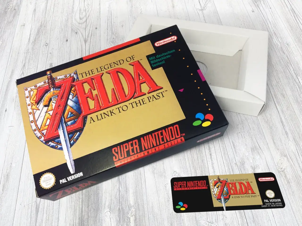 Pudełko gry The Legend of Zelda: A Link to the Past na Super Nintendo, z mieczem i tarczą. Obok otwarte białe pudełko.